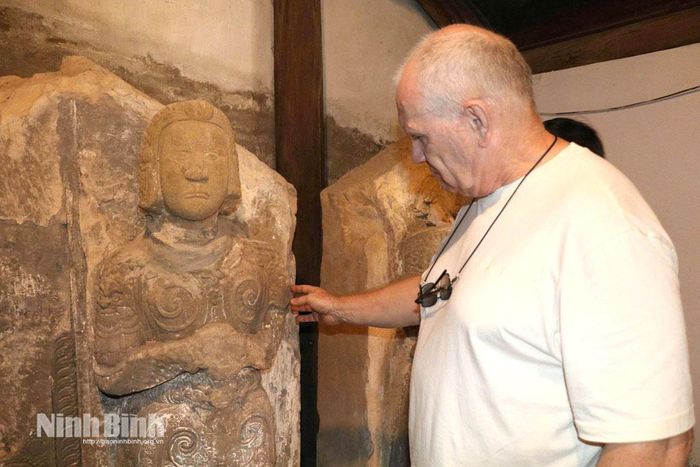 Du khách nước ngoài tìm hiểu về bộ tượng Kim Cương tại chùa Long Đọi Sơn (phường Tiên Sơn).