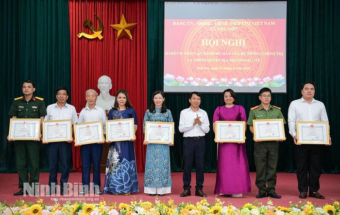 Lãnh đạo xã khen thưởng các cá nhân có thành tích xuất sắc trong thực hiện nhiệm vụ trong một năm qua.