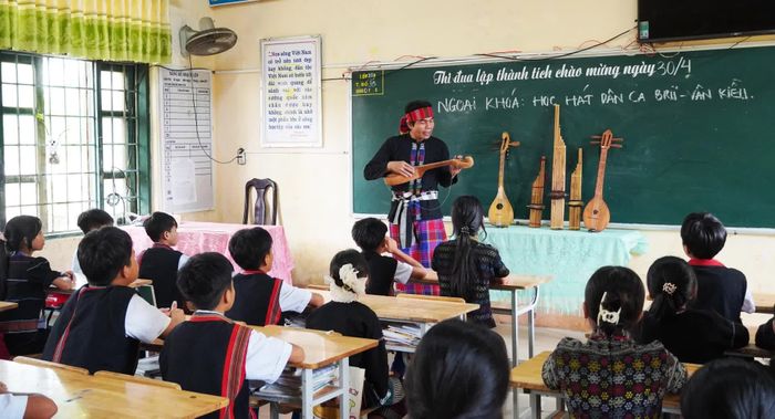 Nghệ nhân Hồ Văn Hồi truyền dạy dân ca và nhạc cụ dân tộc Bru-Vân Kiều cho các em học sinh - Ảnh: P.P
