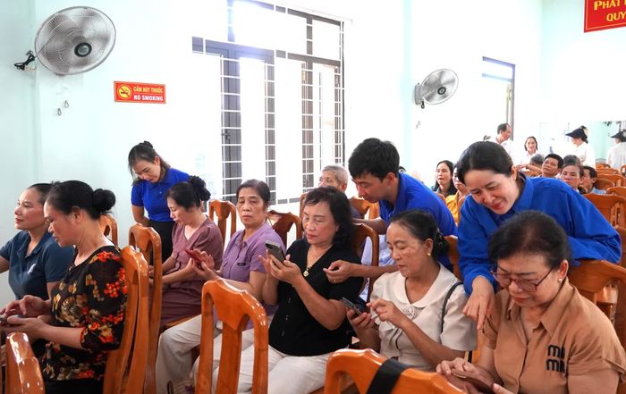 Lực lượng đoàn viên, thanh niên hỗ trợ hướng dẫn người dân sử dụng các ứng dụng số - Ảnh: H.Tr