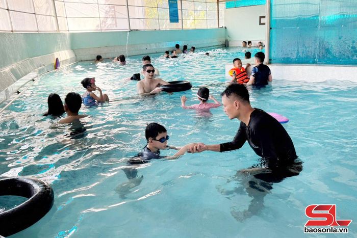 Giáo viên dạy kỹ năng bơi cho trẻ dịp hè.