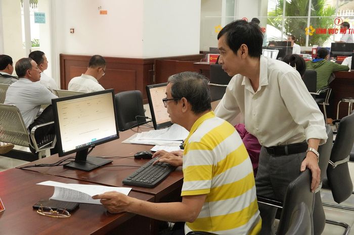Người dân được cán bộ hướng dẫn sử dụng các dịch vụ số làm thủ tục hành chính. Ảnh: Thạc Hiếu