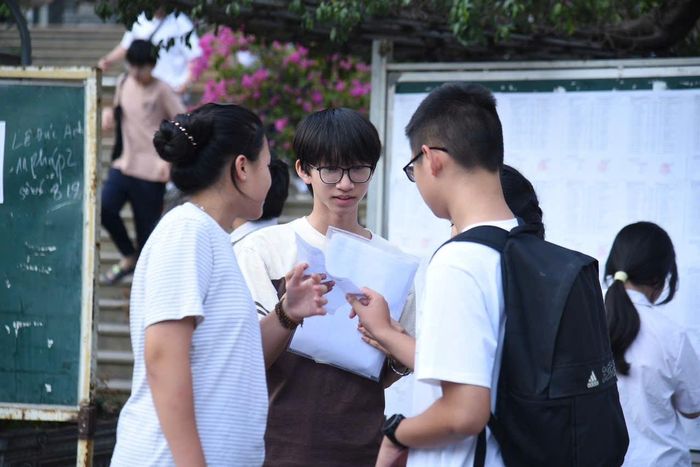 Thí sinh trao đổi nhanh với bạn bè về đề thi môn chuyên ngay khi rời phòng thi. Ảnh: Xuân Quý