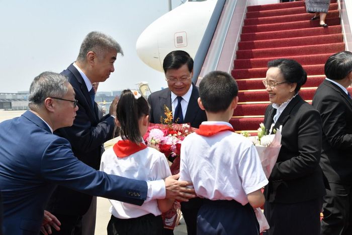 Các em học sinh tặng hoa cho ông Thongloun Sisoulith. Ảnh: Bộ Ngoại giao Lào