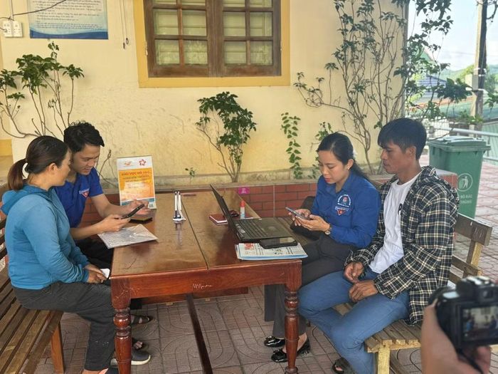 Cán bộ xã hướng dẫn người dân làm thủ tục hành chính qua mạng internet.