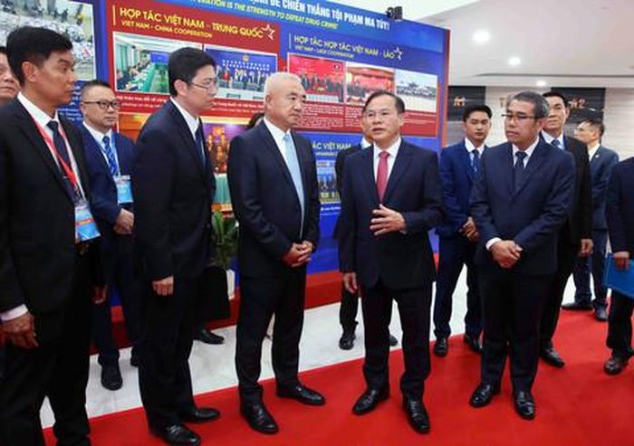 Thượng tướng Nguyễn Văn Long, Thứ trưởng Bộ Công an và các đại biểu tham quan triển lãm ảnh về công tác phối hợp đấu tranh phòng chống ma túy của 4 nước bên lề Hội nghị