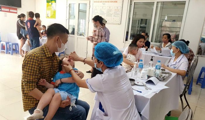 Người dân đưa con đến uống Vitamin A tại các điểm trên địa bàn phường. Ảnh: PV