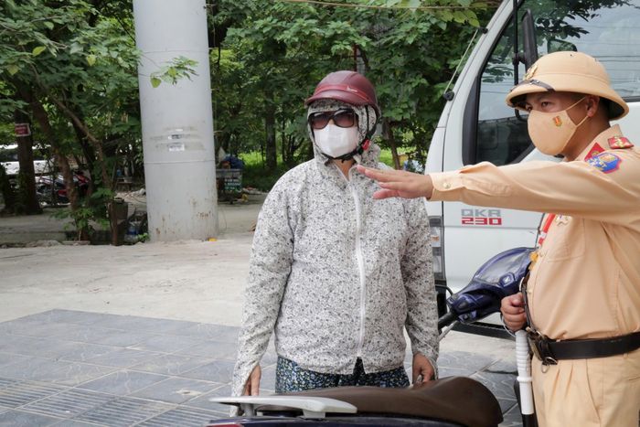 Lực lượng CSGT tuyên truyền pháp luật tới một người dân vượt đèn đỏ đường sắt. Ảnh: Phạm Công