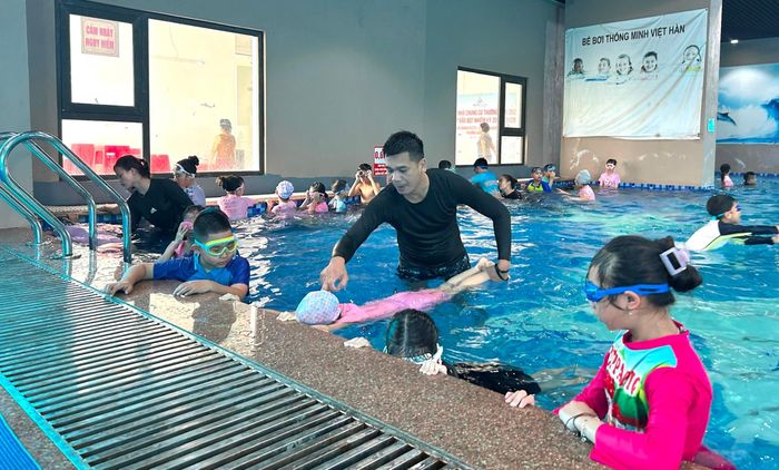 Huấn luyện viên hướng dẫn học sinh các kỹ thuật bơi cơ bản. Ảnh: Trần Oanh.