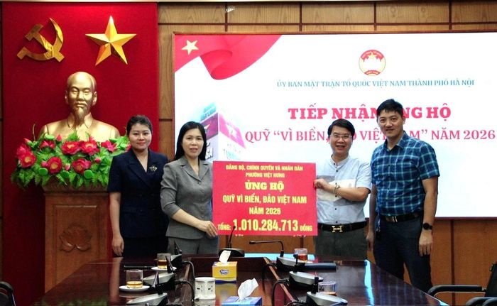 Lãnh đạo Ủy ban MTTQ Việt Nam thành phố Hà Nội (trái ảnh) tiếp nhận kinh phí ủng hộ từ lãnh đạo phường Việt Hưng. Ảnh: PV