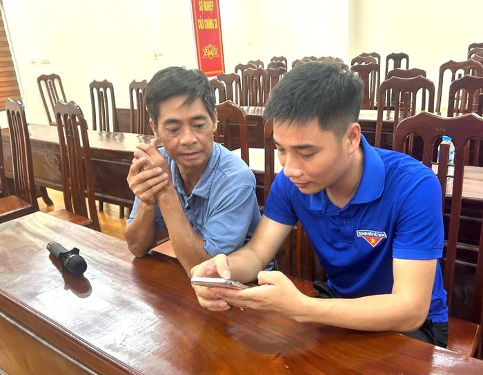 Thanh niên hướng dẫn cán bộ thôn sử dụng công nghệ, AI. Ảnh: DH.