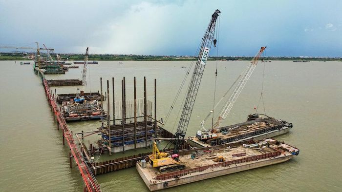 Từ trên cao, khu vực thi công hiện lên nhộn nhịp với hệ thống sà lan, cần cẩu và đường công vụ kéo dài giữa lòng sông Hồng. Ảnh: Thắng Hoàng.