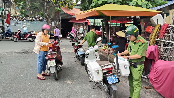  Lực lượng chức năng xử lý những trường hợp dừng đỗ xe, buôn bán sai quy định gây cản trở giao thông. Ảnh: N.TÂN 