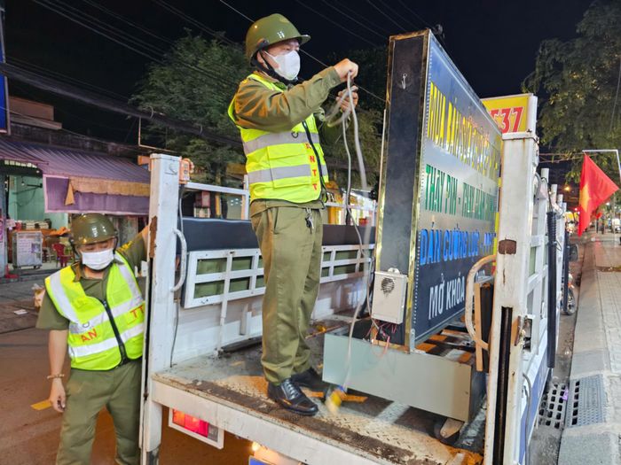  Cơ quan chức năng tạm giữ các biển hiệu lấn chiếm lòng lề đường. Ảnh: N.TÂN 