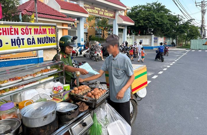  Công an phường Đông Hưng Thuận lập biên bản người vi phạm trật tự đô thị, lấn chiếm lòng lề đường. Ảnh: N.TÂN 
