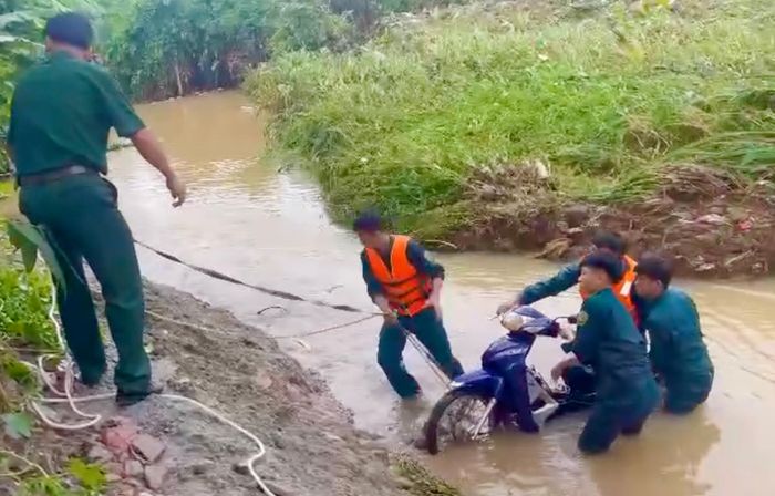  Lực lượng chức năng xã Phú Riềng tìm thấy xe máy của người dân bị nước cuốn trôi xuống suối. Ảnh: Quốc Triền 