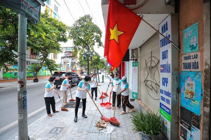 Các hội viên Chi hội Phụ nữ hăng say quét lá, thu dọn rác thải trên tuyến phố Cửa Bắc - Hà Nội. Ảnh: Lê Đông - TTXVN