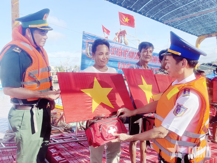  Lãnh đạo Vùng Cảnh sát biển 3 tặng cờ Tổ quốc và túi thuốc y tế cho ngư dân.