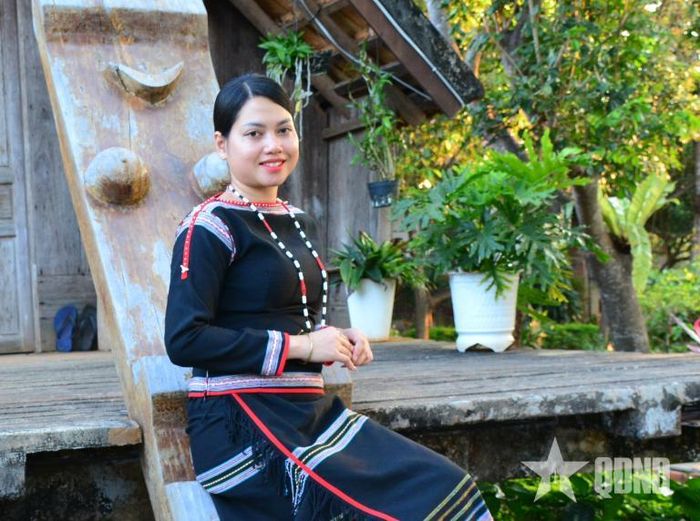 H Zu Ni Niê bên cầu thang nhà dài truyền thống.