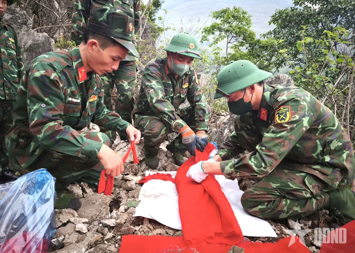Cán bộ, chiến sĩ Đội tìm kiếm, quy tập hài cốt liệt sĩ Bộ CHQS tỉnh Tuyên Quang cẩn trọng cất bốc, bọc hài cốt liệt sĩ vừa được phát hiện tại hiện trường. 