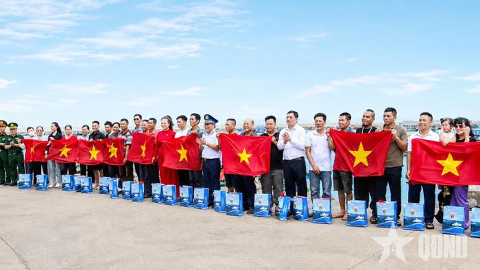  Đoàn công tác Vùng 1, Cảnh sát biển Việt Nam cùng các tỉnh tặng cờ Tổ quốc và trao quà tặng ngư dân bám biển. Ảnh: ĐỨC NGUYỄN 