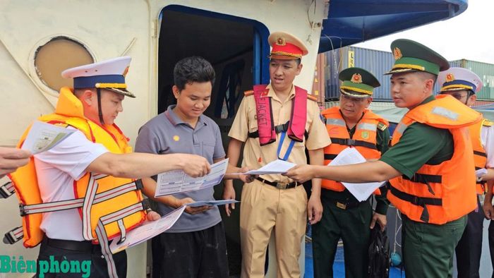 Cán bộ Trạm kiểm soát Biên phòng cửa khẩu cảng Nhà Rồng phối hợp với các lực lượng chức năng trên địa bàn tuyên truyền và cấp phát tờ rơi, tờ gấp tuyên truyền pháp luật cho người dân. Ảnh: Lương Kiểm