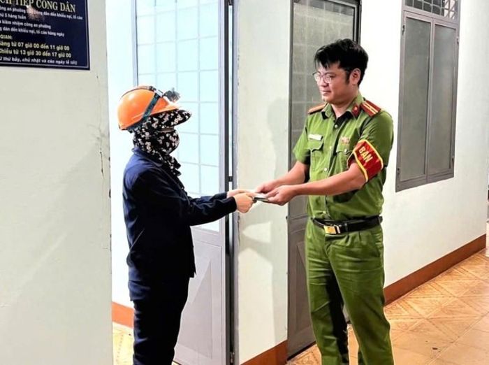 Chị Dương Thị Ánh Hồng bàn giao số tiền nhặt được cho trực ban Công an phường Pleiku. Ảnh: ĐVCC