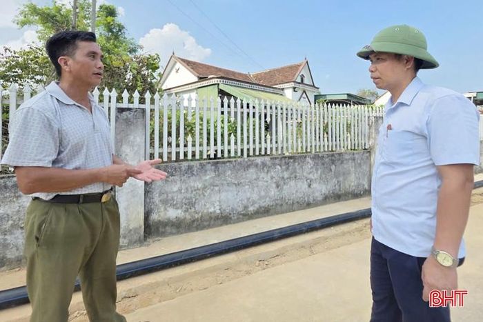 Ông Phan Hải Triều (bên trái) trao đổi với cán bộ xã Trường Lưu về tinh thần phối hợp, giúp đỡ của người dân đối với đơn vị thi công trong quá trình triển khai dự án.