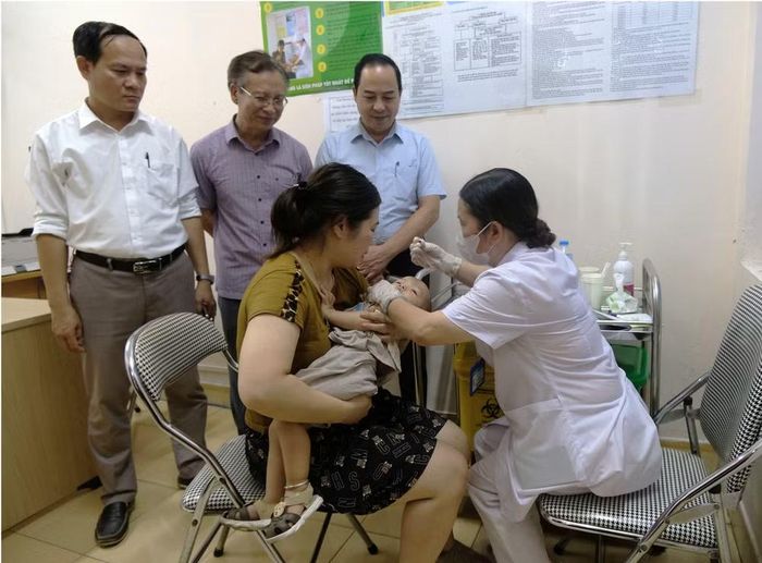 Viện trưởng Viện Dinh dưỡng, PGS.TS.Trần Thanh Dương cho trẻ uống Vitamin A. (Ảnh: PV/Vietnam+)