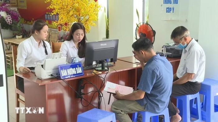 Người dân phường Bến Cát được hướng dẫn đăng ký, nộp hồ sơ thủ tục hành chính trực tuyến, thanh toán điện tử và cài đặt, đăng nhập tài khoản VNEID. (Ảnh: Hữu Duyên/TTXVN)