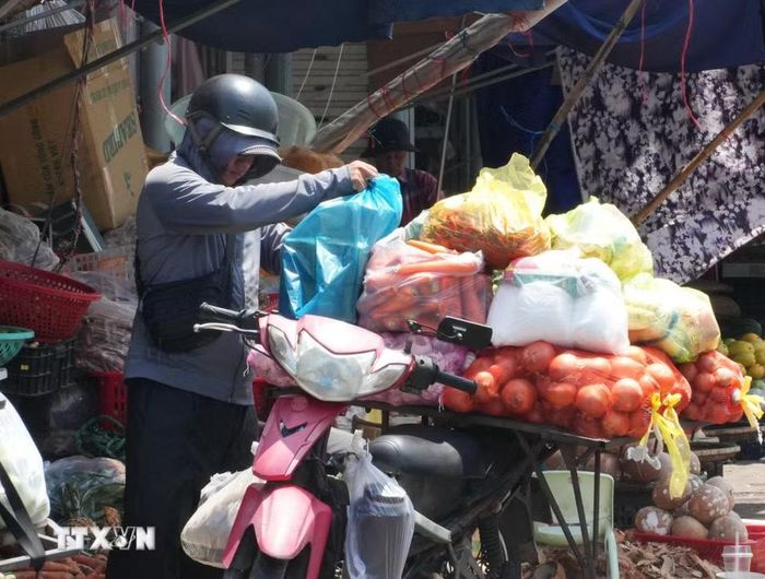 Người dân sắp xếp, vận chuyển hàng hóa dưới nắng nóng gay gắt ở khu vực chợ Đông Ba, phường Phú Xuân, thành phố Huế. (Ảnh: Nguyên Lý/TTXVN)