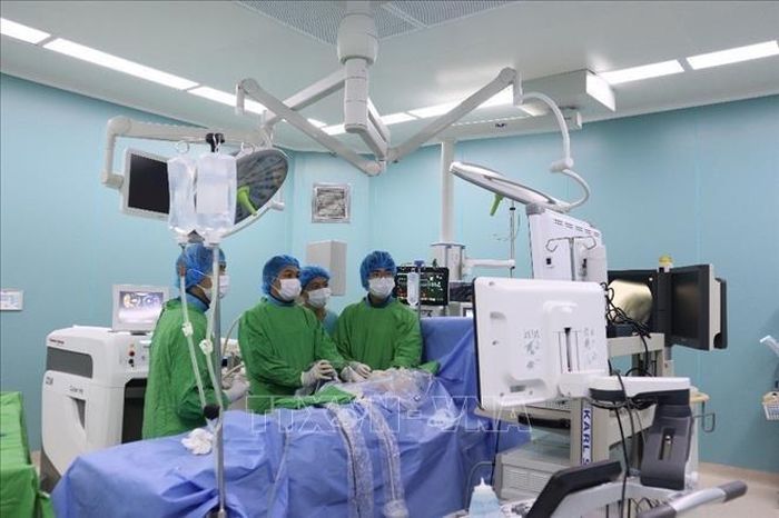 Các bác sĩ thực hiện kỹ thuật tán sỏi đường mật qua đường hầm xuyên gan bằng laser. Ảnh: TTXVN phát