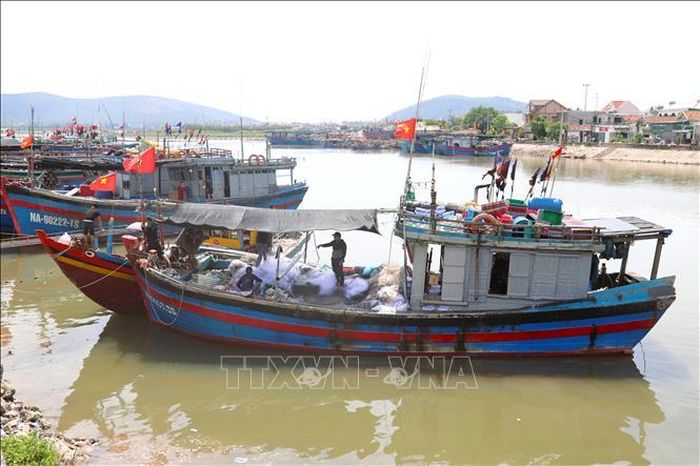 Ngư dân Nghệ An căng phông bạt tạo bóng mát trên khoang tàu cá trong lúc chuẩn bị ngư lưới cụ trước khi vươn khơi.