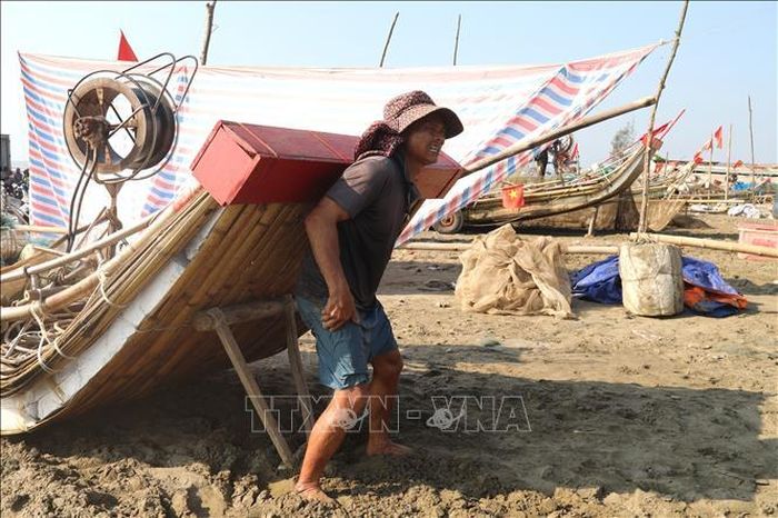 Ngư dân làng biển Tiền Tiến (xã Hải Châu, tỉnh Nghệ An) vất vả dùng lưng nâng cao mũi bè mảng trong thời tiết giữa trưa nắng để chuẩn bị ra khơi.