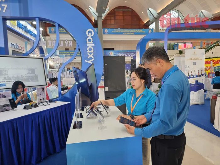 Các đại biểu tìm hiểu về mẫu điện thoại mới tại gian hàng của Liên đoàn Lao động tỉnh Bắc Ninh.