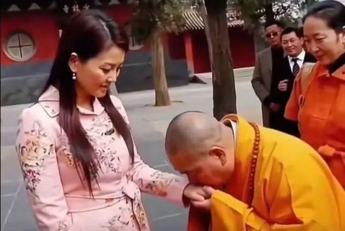 Thích Vĩnh Tín hôn tay nữ du khách, cử chỉ bị chỉ trích. Ảnh: Sohu.