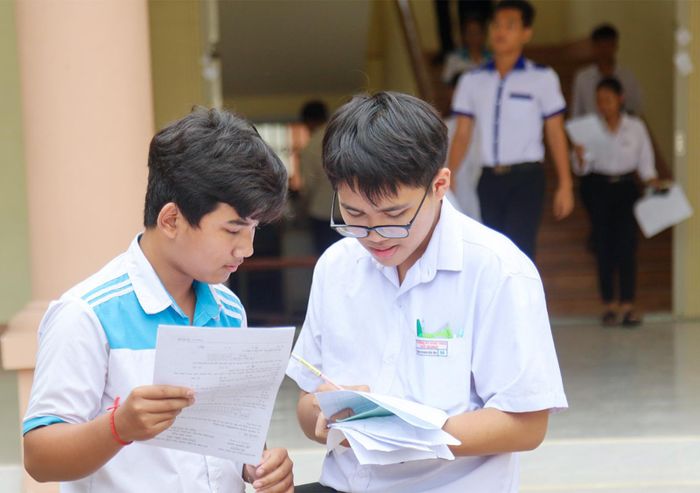 Em Danh Hoàng Mến (bên trái) - học sinh Trường THCS Thủy Liễu, xã Định Hòa thảo luận đáp án môn Toán cùng bạn. Ảnh: BÍCH TUYỀN