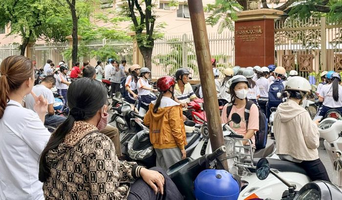 Bên ngoài cổng Trường THPT chuyên Thoại Ngọc Hầu, phường Long Xuyên, đông phụ huynh dõi theo con. Ảnh: PHƯƠNG LAN