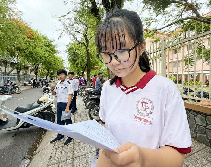 Em Đào Thiên Thanh, học sinh Trường Phổ thông Thực hành Sư phạm (phường Long Xuyên), xem lại đề thi môn Toán. Ảnh: PHƯƠNG LAN