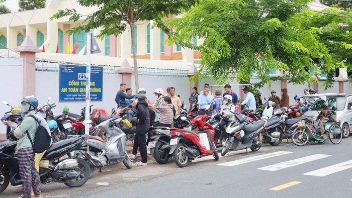 Bên ngoài cổng Trường Phổ thông Dân tộc nội trú THPT An Giang 1, phường Rạch Giá, đông đảo phụ huynh hồi hộp đợi tin con. Ảnh: BÍCH TUYỀN