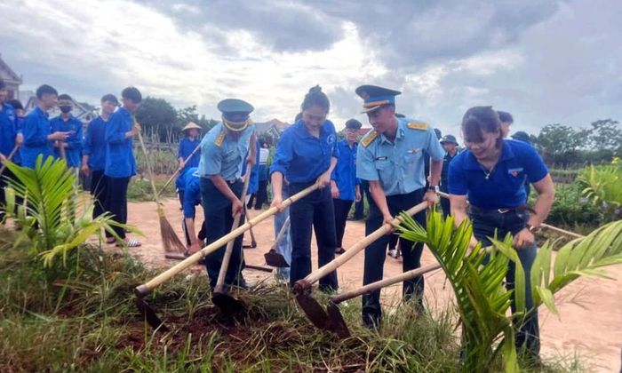  Cán bộ, chiến sĩ Trung đoàn 228 cùng đoàn thanh niên địa phương phát quang hành lang đường giao thông. 