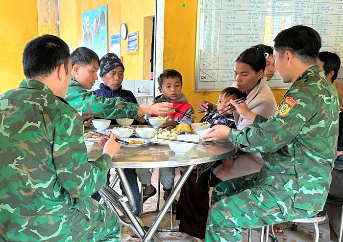 Cán bộ, chiến sĩ biên phòng chăm lo bữa ăn cho người dân biên giới. Ảnh: SONG NGUYÊN