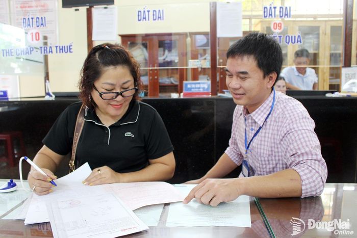 Cán bộ phường Bình Long giải quyết thủ tục hành chính cho người dân.