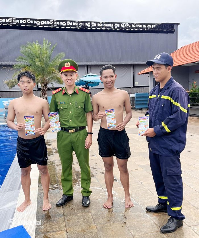 Cán bộ, chiến sỹ Đội Chữa cháy và CNCH khu vực 13 phát tờ rơi kỹ năng phòng chống đuối nước cho phụ huynh và học sinh trên địa bàn