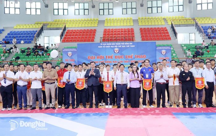 Ban tổ chức trao cờ lưu niệm cho các đoàn vận động viên. Ảnh: Thổ Tín
