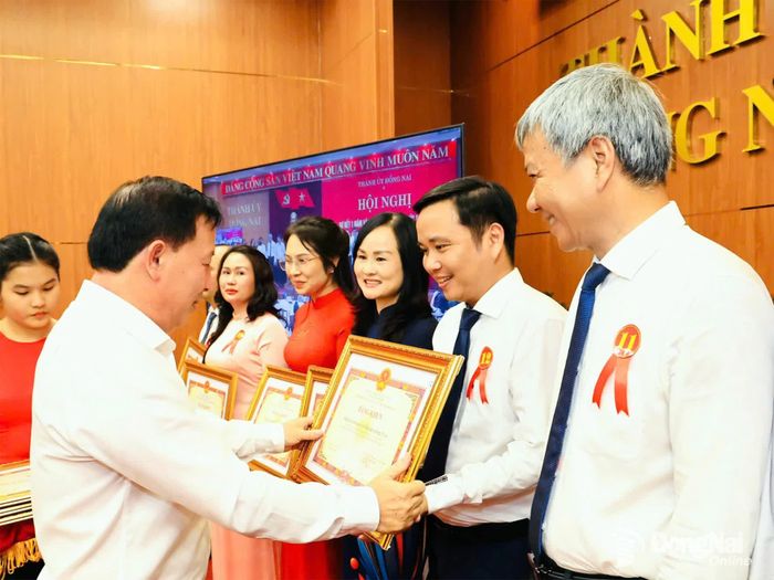 Phó Bí thư Thành ủy, Chủ tịch UBND thành phố Nguyễn Văn Út trao bằng khen cho các tập thể đạt thành tích xuất sắc trong thực hiện mô hình chính quyền địa phương 2 cấp. Ảnh: Công Nghĩa