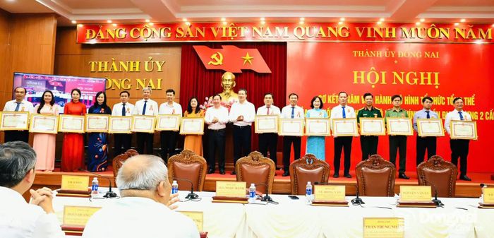 Đồng chí Vũ Hồng Văn, Ủy viên Trung ương Đảng, Bí thư Thành ủy, Trưởng đoàn Đại biểu Quốc hội thành phố và đồng chí Nguyễn Văn Út, Phó Bí thư Thành ủy, Chủ tịch UBND thành phố trao bằng khen cho các tập thể có thành tích xuất sắc trong thực hiện mô hình chính quyền địa phương 2 cấp. Ảnh: Công Nghĩa