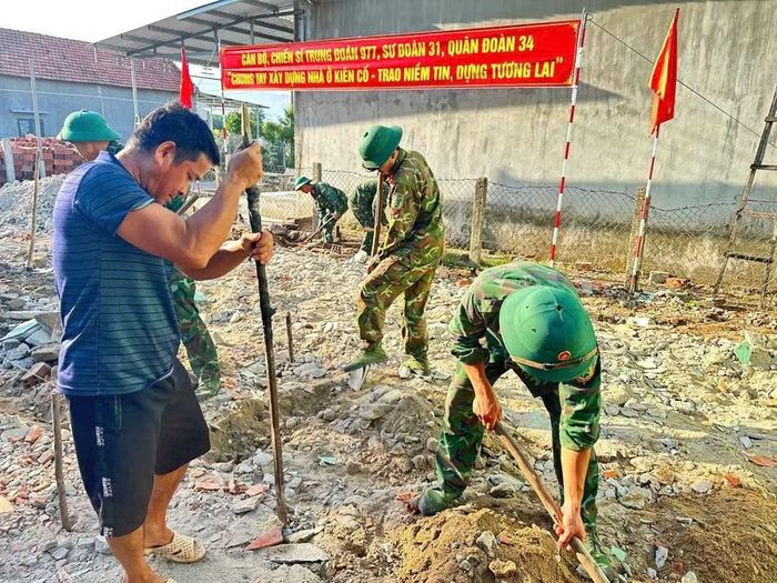  Cán bộ, chiến sĩ Trung đoàn 977 (Sư đoàn 31) hỗ trợ ngày công giúp gia đình bà Đinh Thị Nguyệt (xã Vĩnh Thạnh) xây dựng nhà ở. Ảnh: H.P 
