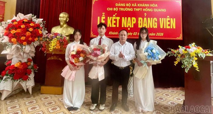 Bí thư Chi bộ Trường THPT Hồng Quang trao Quyết định kết nạp Đảng và tặng hoa chúc mừng đảng viên mới.