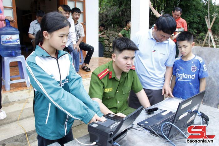 Cán bộ Công an phường Chiềng Cơi thu nhận hồ sơ tài khoản định danh điện tử cho trẻ em bản San.